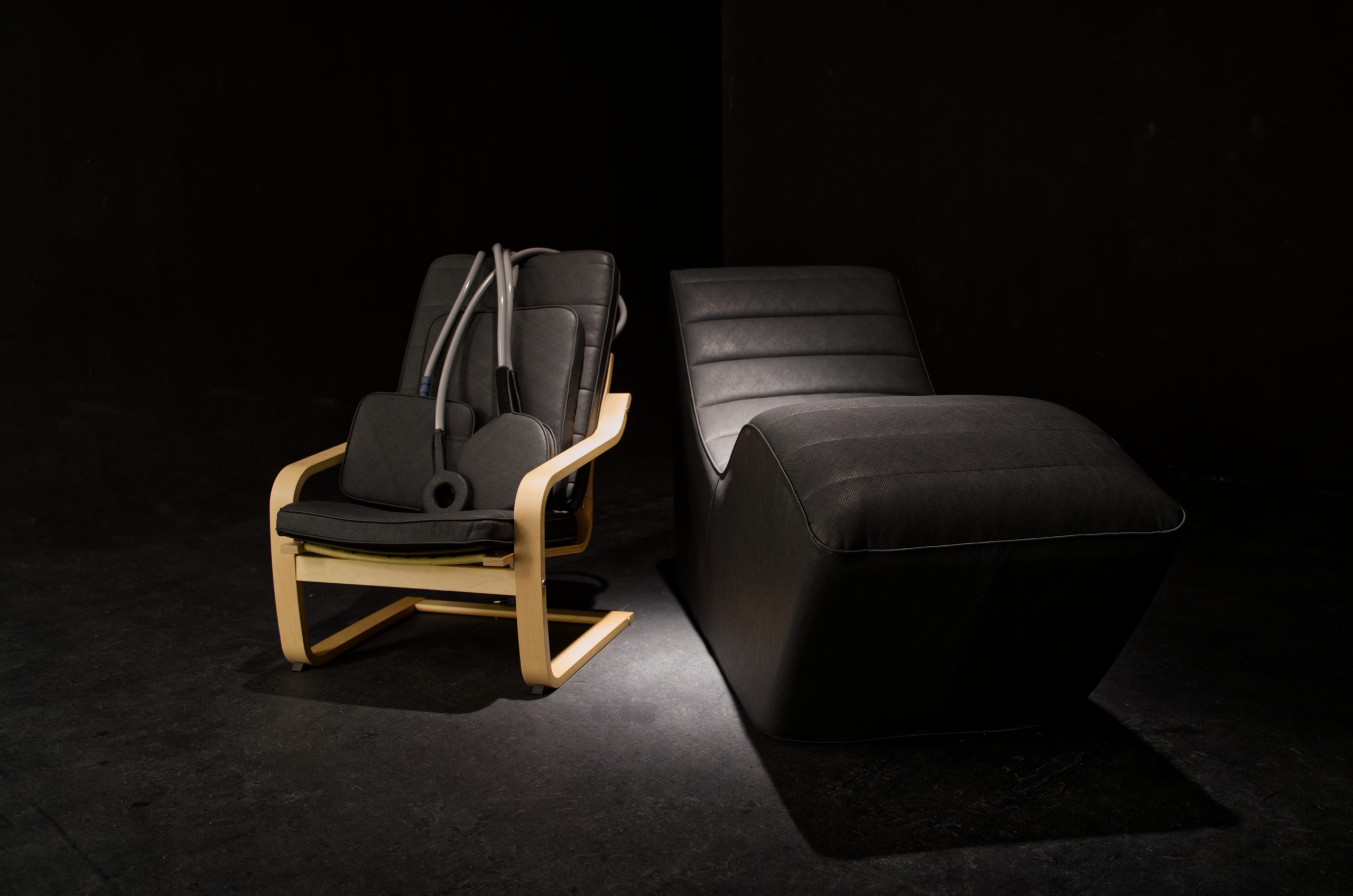 Pulse PEMF chair and chaise, upholstered in dark Ultrafabrics, in low dramatic light